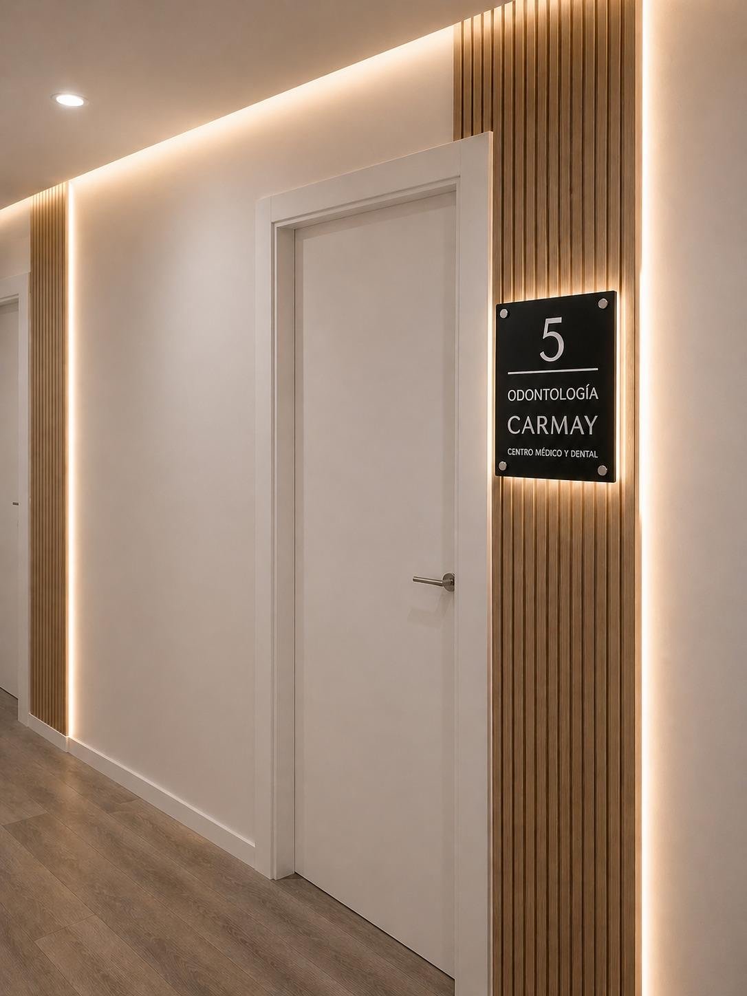 Puerta de una consulta de CARMAY con su placa iluminada.